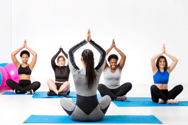 Young woman doing easy asanas, breathing exercises and meditating during group  yoga Stock Photo - Alamy